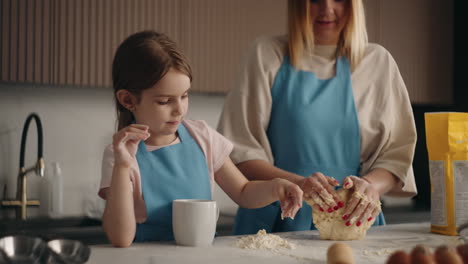 mother-and-little-daughter-are-baking-bread-in-home-woman-is-kneading-dough-and-child-is-helping
